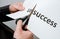 Man cutting inscription on a paper with scissors