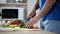 Man cutting tomatoes and lettuce preparing fresh vegetable salad, healthy eating