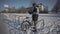 Man cyclist locks bicycle in a street parking lot in Europe in winter snowy weather. Locking bike for parking