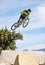 Man, cyclist and mountain biking in free style, tricks or extreme hill jumping in the nature outdoors. Professional male