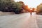 Man cyclist pedaling on a road bike outdoors in sun set