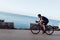 Man cyclist pedaling on a road bike outdoors in sun set