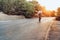 Man cyclist pedaling on a road bike outdoors in sun set