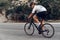 Man cyclist pedaling on a road bike outdoors in sun set