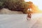 Man cyclist pedaling on a road bike outdoors in sun set