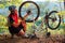 Man cyclist repairing a bike against blue sky