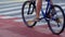 Man cyclist riding crosswalk on bicycle. Male legs rolling wheels close up.