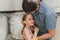Man dad having time with kid daughter girl nine year hugs and straighten her hair. happy father playing with child. real life auth