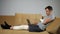 Man with damaged knee and forearm works distantly via laptop