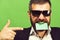 Man with dark beard holds green business card in teeth