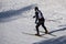 A man in dark clothes, goes into the distance along the path in the snow, on a winter day