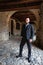 Man in dark elegant suit posing under the arcades