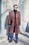 Man with dark red trench coat with abstract design before Wood Wood fashion show, Milan Fashion Week street