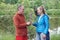 Man on a date gives woman a bell flower in the summer in a park on the lake shore