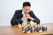 Man with deep thinking expression running steps while playing chess