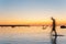 Man defocused silhouette walking in sea water at sunset