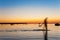 Man defocused silhouettes walking in sea water at sunset