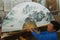 Man demonstrates traditional painted Chinese fan in a fan workshop in Yangshuo, China.