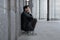 a man in a depressed state sits leaning back against the wall and covering his hands with his palms