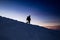 A man descends from the top of the mountain at sunset, the texture of snow is visible