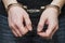 Man detained in handcuffs. Prisoner or arrested man in handcuffs. Male hands in handcuffs. Criminal law