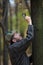 Man detective with a beard examines single dry leaf