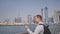 The man dials the number on the phone and talks on the background of the panorama of Dubai. Hand close-up.