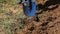 Man digging in garden using hand shovel