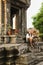 Man With Digital Camera Sitting On Steps Of Ancient Temple