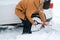 A man digs out a stalled car in the snow with a car shovel. Transport in winter got stuck in a snowdrift after a snowfall, sat on