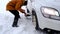 Man digs out stalled car in snow with car shovel. Transport in winter got stuck in a snowdrift after a snowfall, sat on bottom. Fi