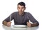 Man at dinner table with fork and knife raised.