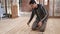 Man in dirty clothes doing repairs covering floor inside house