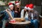 man with disability with amputated arms has fun with friends in red Santa hats