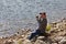 Man with a disability sits by the river and enjoys the sun