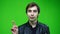 Man disapproving waving his finger, making negation finger gesture. over green screen background.