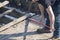 Man Dismantling an Old Wooden Deck with a Red Crowbar  1