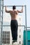 Man do chin ups outdoor. Sportsman pull up on stadium. Athlete with fit torso and strong hands on bar. Chin up bar exercises. Work