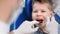 Man doctor hands in gloves examining mouth cavity of child. Shot on RED Raven 4k Cinema Camera