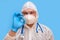 Man doctor medic in a protective suit uniform with goggles and face mask on a studio blue background. Paramedic in white antiviral
