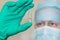 Man in doctor`s cap and mask holds in sterile glove a ampoule with a remedy