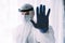 Man doctor or scientist waring protective suit and face mask , STOP, hand gesture