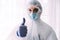 Man doctor or scientist wearing protective suit and face mask thumb up, hand gesture