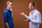 Man doctor and young man patient against brown background