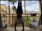 Man does Handstand on top on hill in front of buildings