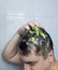 Man does head scrub. Dark-haired young man applies a scalp scrub to combat dandruff, oily scalp, alopecia. Problem skin causing