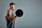 Man doing back workout, barbell row in studio over gray background. Copy space