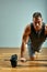 Man doing back workout, barbell row in studio over gray background. Copy space