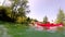 Man doing backflip from canoe into water while girl paddling canoe