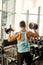 Man doing exercise with dumbbell leaning on sports bench in the gym. Photo of a sexy muscular man in sportswear and good